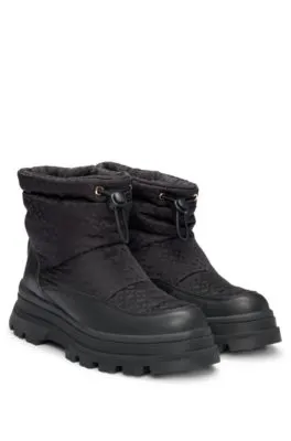 Botas slim fit con motivo de monogramas y apliques de piel